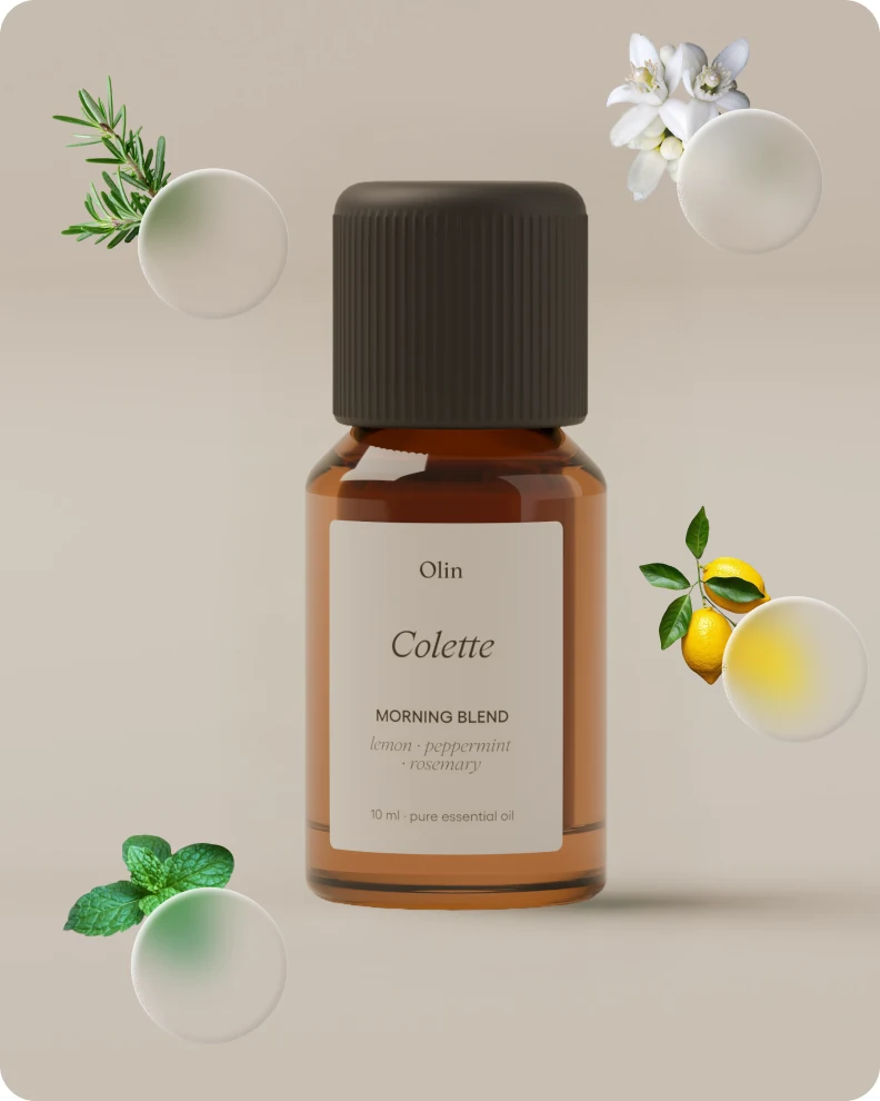 Colette morning blend bottle surrounded by its ingredients: rosemary, lemon, peppermint and orange blossom